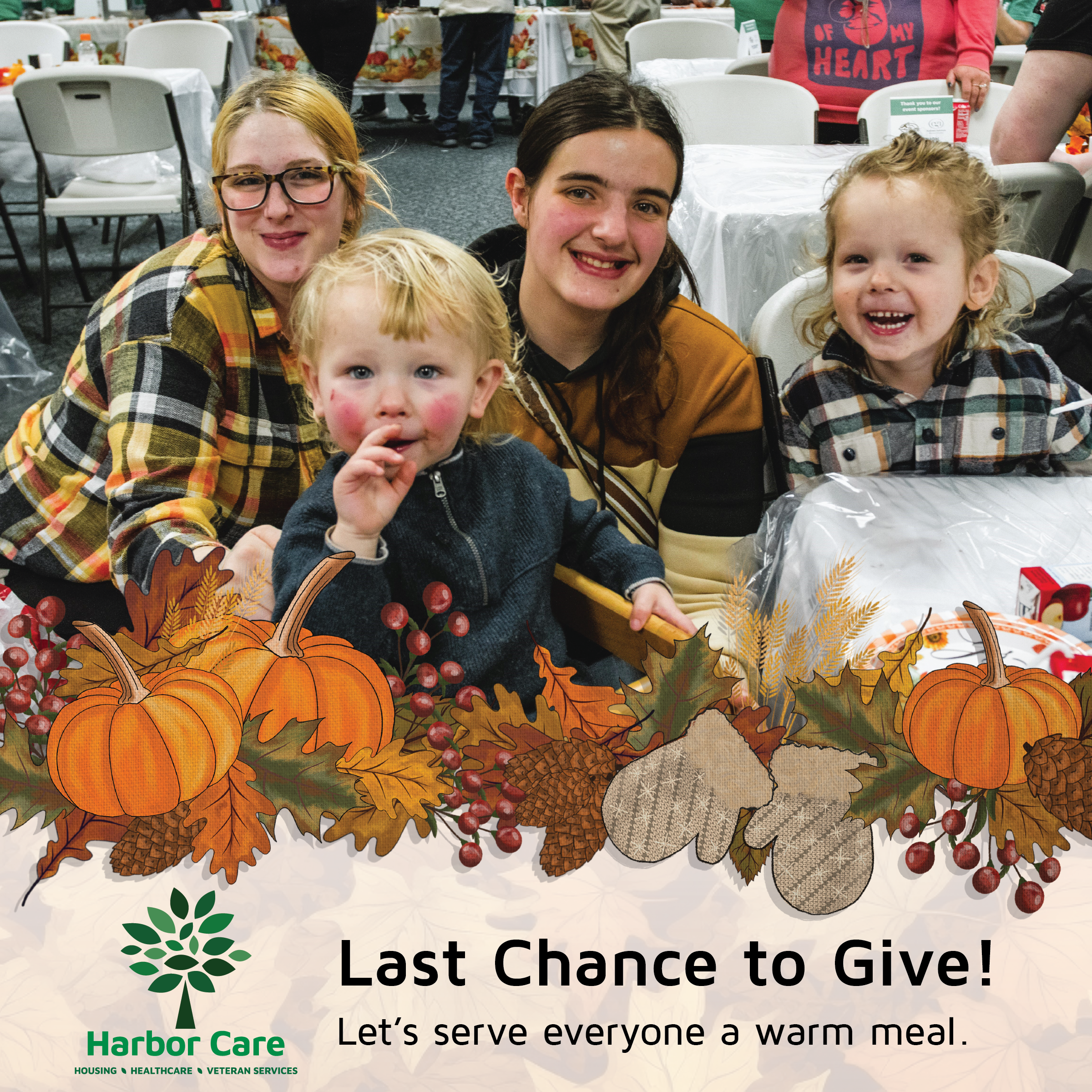 Last Call to Help Image Four people, including two children and two adults, sit at a table with autumn decorations, smiling for the camera at a community meal event. Text encourages donations for warm meals.