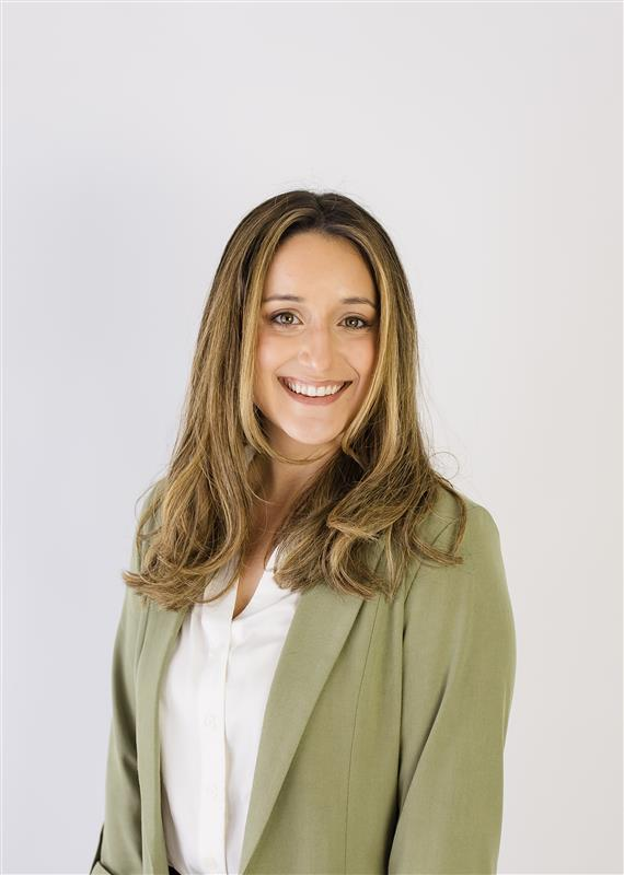 Jessica Campbell A woman with long, light brown hair wearing a light green blazer and white blouse, smiling in front of a plain white background.